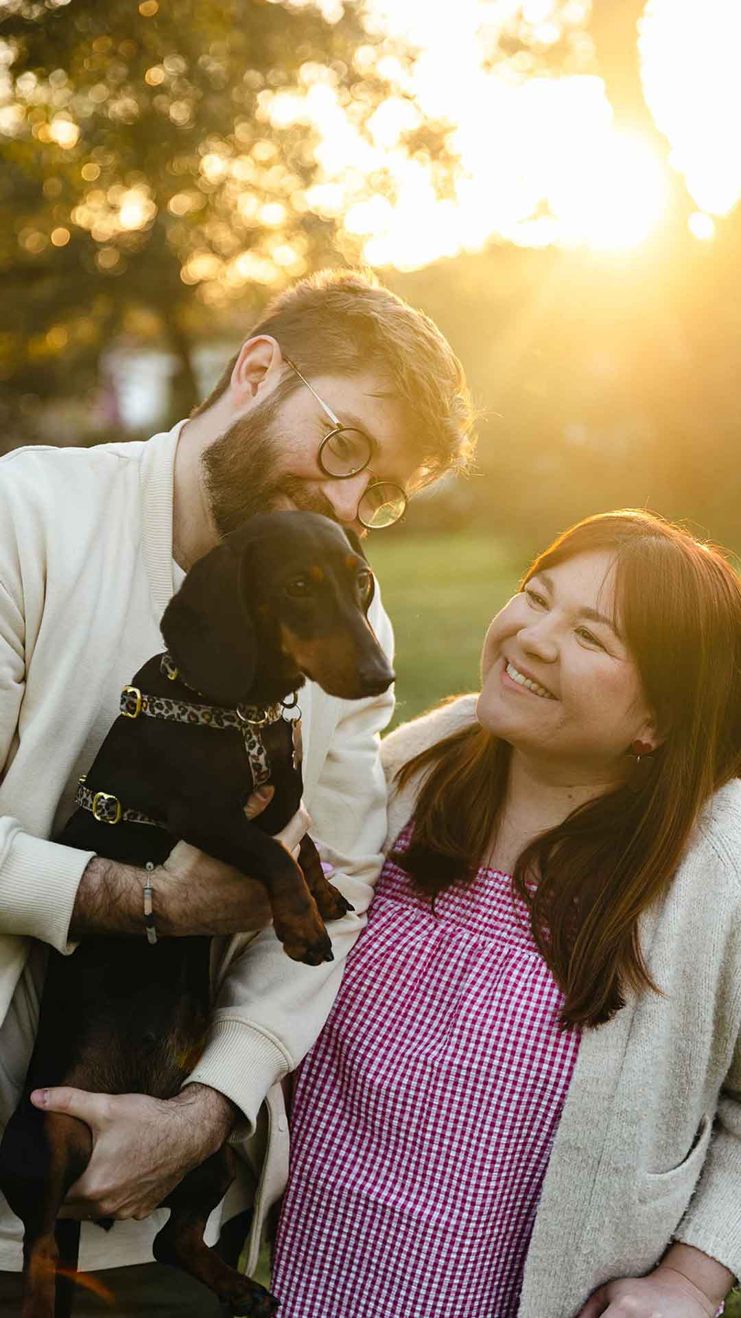 Photo d'un jeune couple souriant tenant un chien dans les bras